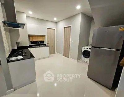 Modern kitchen with sleek appliances and glossy flooring