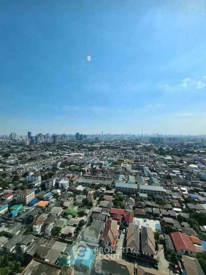 Stunning aerial cityscape view showcasing urban skyline and residential rooftops under clear blue sky.