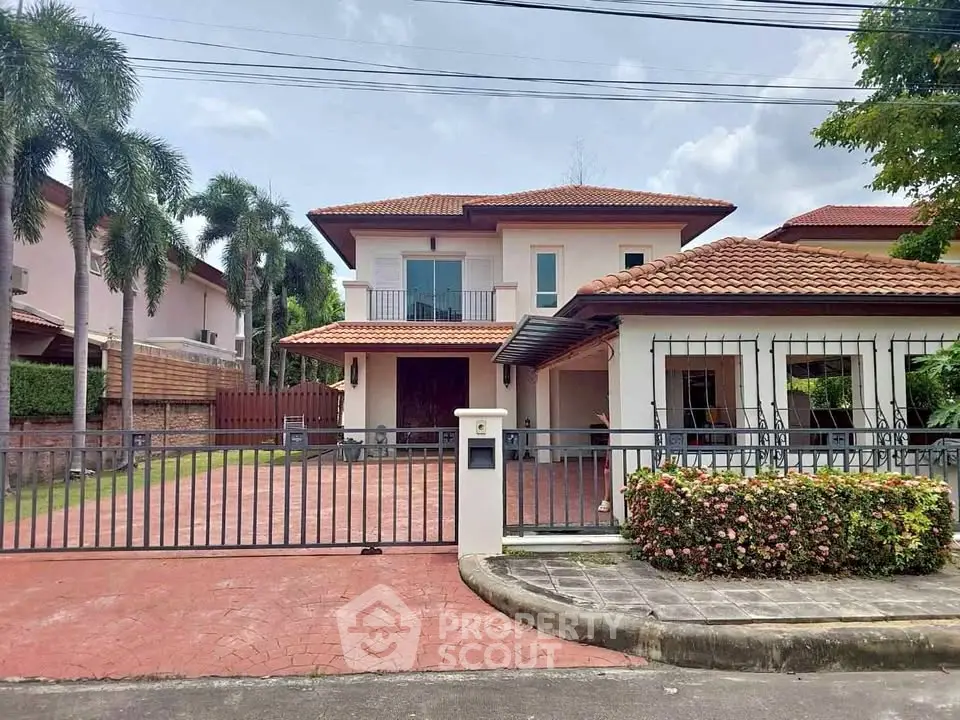 Charming two-story house with gated driveway and lush garden