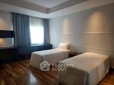 Spacious bedroom with twin beds and elegant wooden flooring