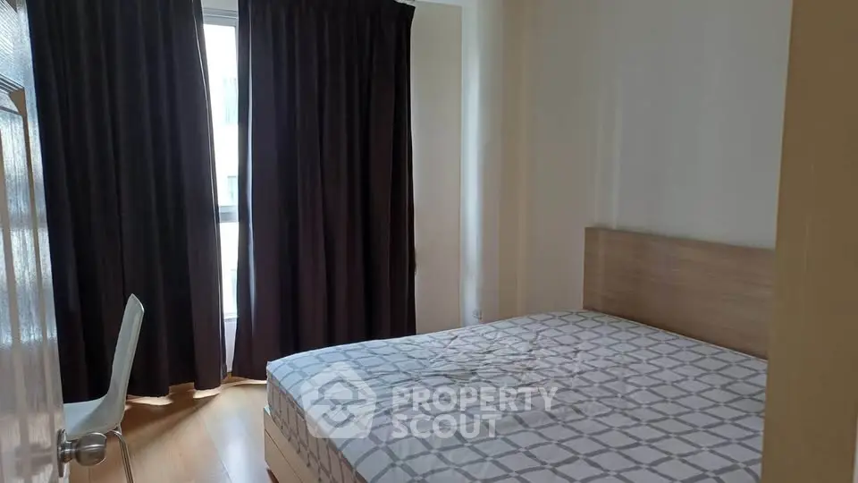 Cozy bedroom with natural light and modern furnishings in a stylish apartment.