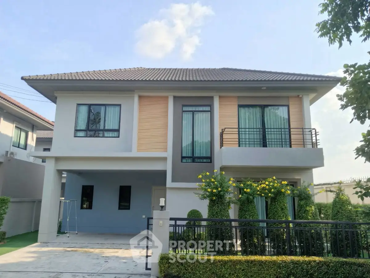 Modern two-story house with landscaped garden and balcony in a serene neighborhood.