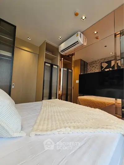 Modern bedroom with sleek design, featuring a cozy bed, built-in wardrobe, and air conditioning unit.