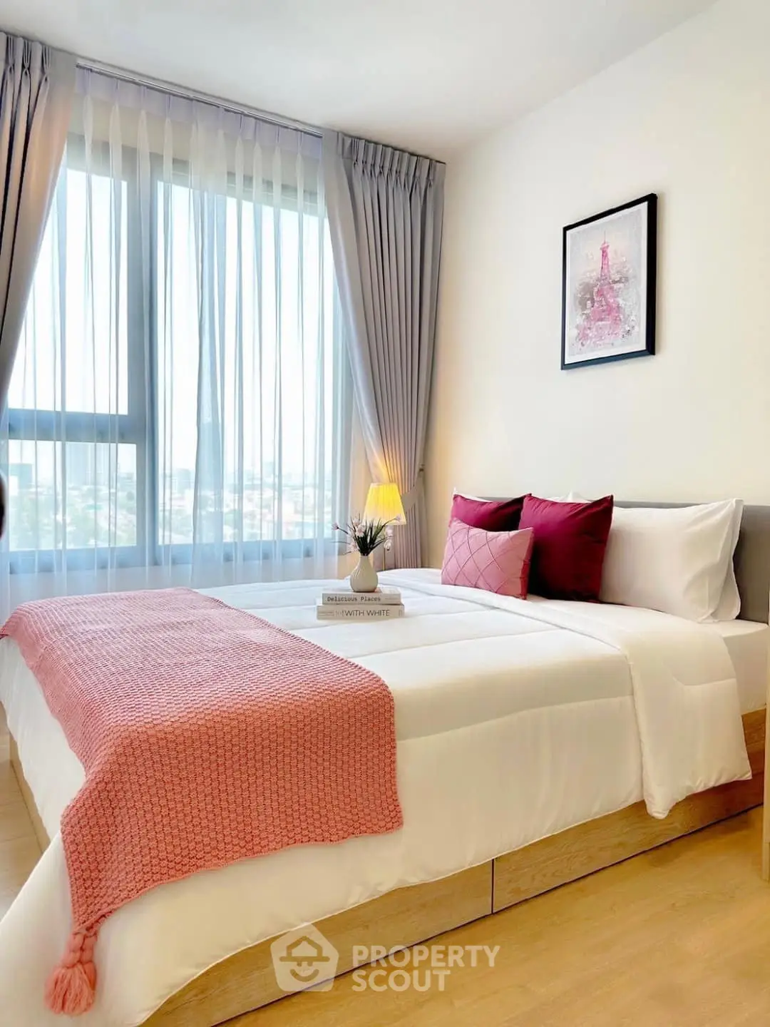 Bright and cozy bedroom with large window and stylish decor, perfect for relaxation.