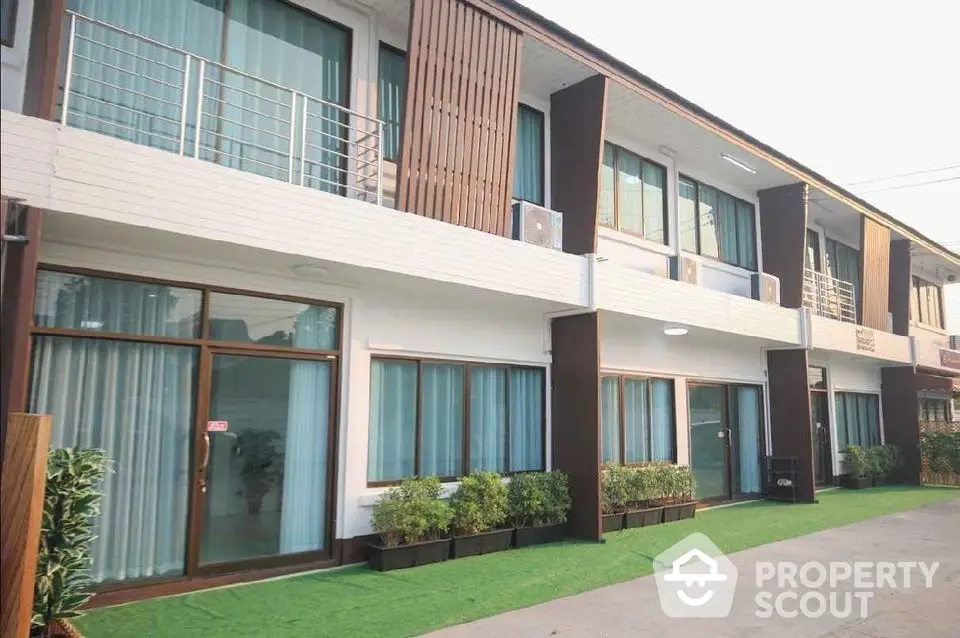 Modern townhouse exterior with green landscaping and large windows