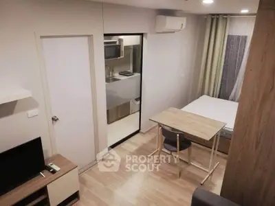 Modern studio apartment with open layout, featuring a cozy living area and compact kitchen.
