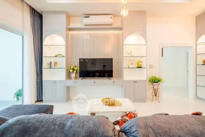 Luxurious living room with modern decor and elegant lighting, featuring a sleek TV setup and plush seating.