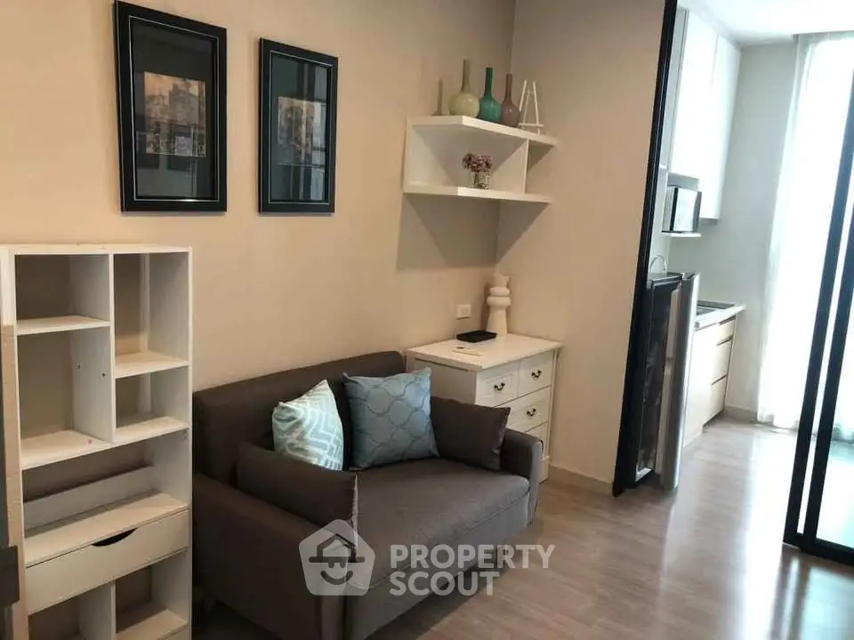 Cozy living room with modern decor and compact kitchen in a stylish apartment.