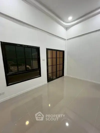 Spacious empty room with large windows and glossy tiled floor, perfect for customization.