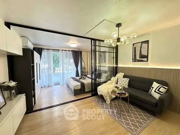 Modern studio apartment with stylish decor and glass partition separating bedroom and living area.