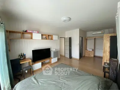Spacious bedroom with modern decor and entertainment setup