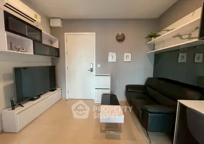 Modern living room with sleek furniture and wall-mounted TV in a stylish apartment.