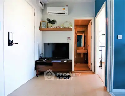 Modern living room with TV, air conditioning, and stylish decor in a cozy apartment.