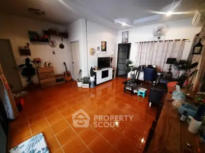 Spacious living room with terracotta tiles, cozy decor, and ample natural light.