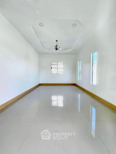 Spacious empty room with elegant ceiling design and glossy tiled floor