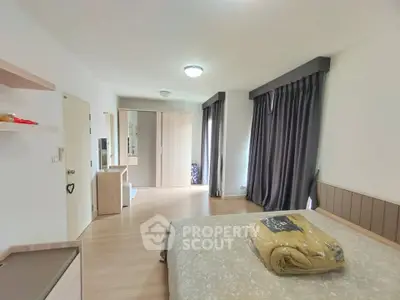 Spacious bedroom with modern decor and ample natural light, featuring elegant curtains and a cozy bed.