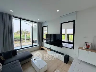 Modern living room with large windows and sleek furniture, offering a bright and inviting atmosphere.