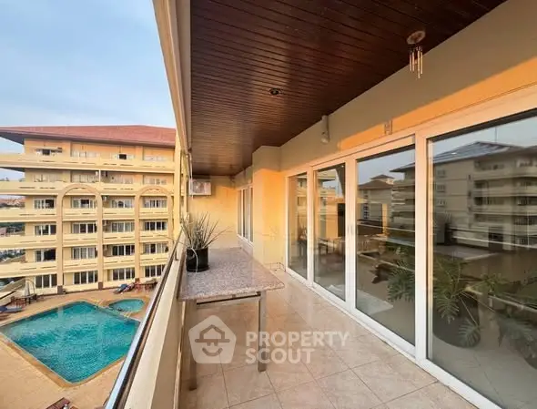 Spacious balcony with pool view in modern apartment complex
