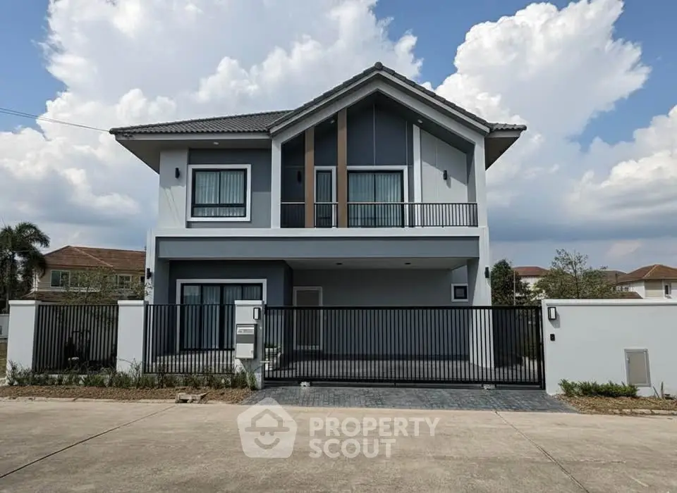 Modern two-story house with sleek design and gated entrance in a suburban neighborhood.