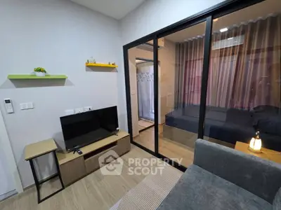 Modern living room with glass partition and cozy bedroom view