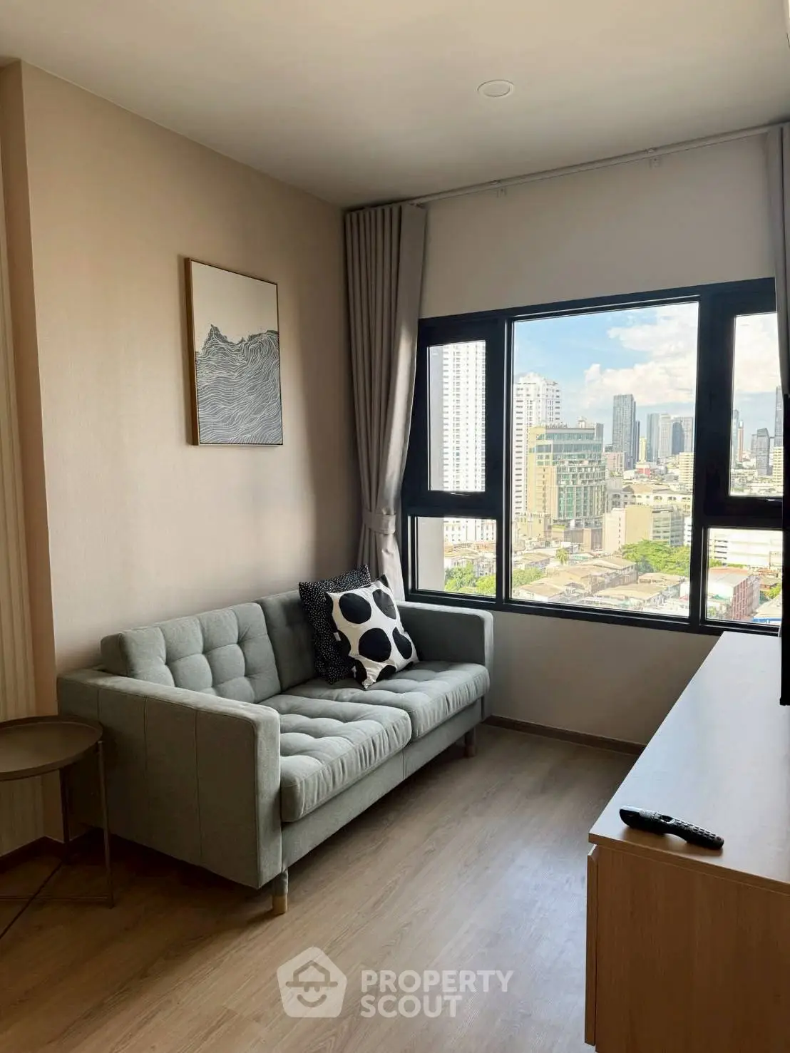 Modern living room with city view, featuring a stylish sofa and large window.