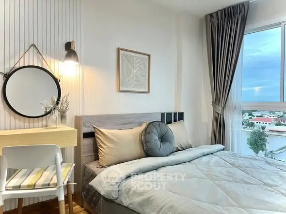 Cozy bedroom with modern decor and large window offering scenic views.