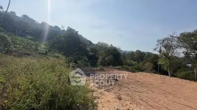 Scenic land plot with lush greenery and mountain views, perfect for development.