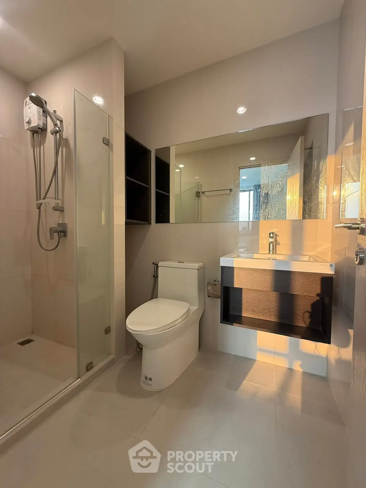 Modern bathroom with glass shower and sleek fixtures in a contemporary apartment.