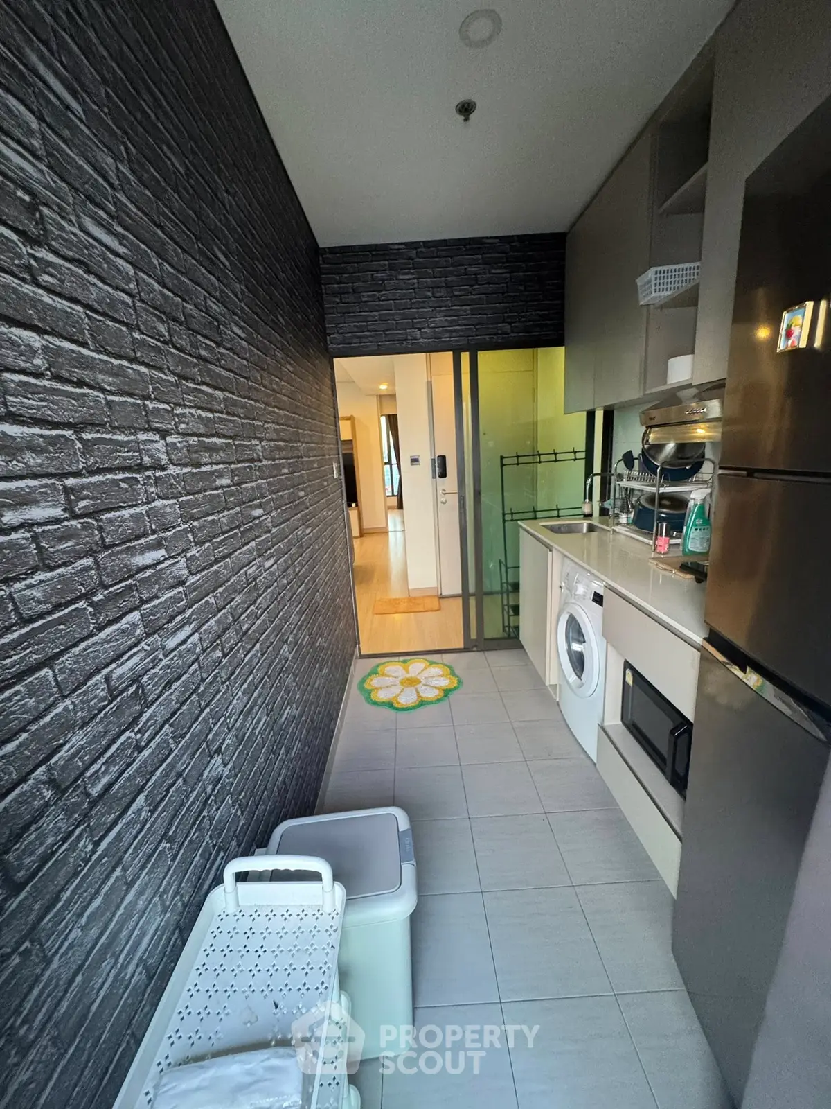 Modern kitchen with washing machine and sleek appliances in a stylish apartment.