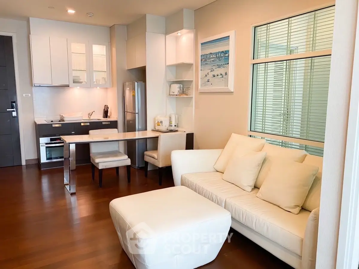 Modern open-layout living room with sleek kitchen and cozy seating area, perfect for urban living.