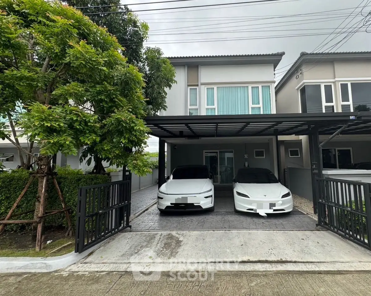 Modern two-story house with carport and electric vehicles in driveway