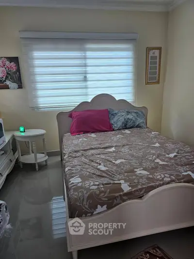Cozy bedroom with elegant decor and natural light, featuring a stylish bed and modern furnishings.