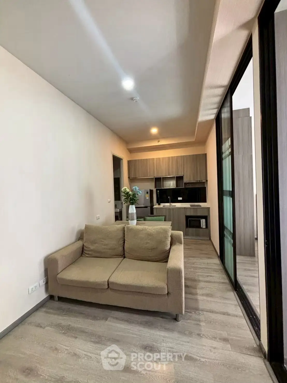 Modern open-plan living room with cozy sofa and sleek kitchen design