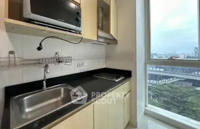 Modern kitchen with sleek cabinetry and city view from large window