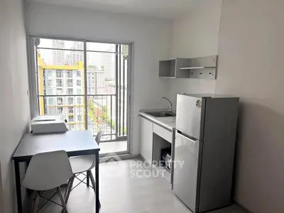 Modern compact kitchen with balcony view in urban apartment