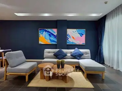 Modern living room with stylish furniture and vibrant artwork on dark accent wall.