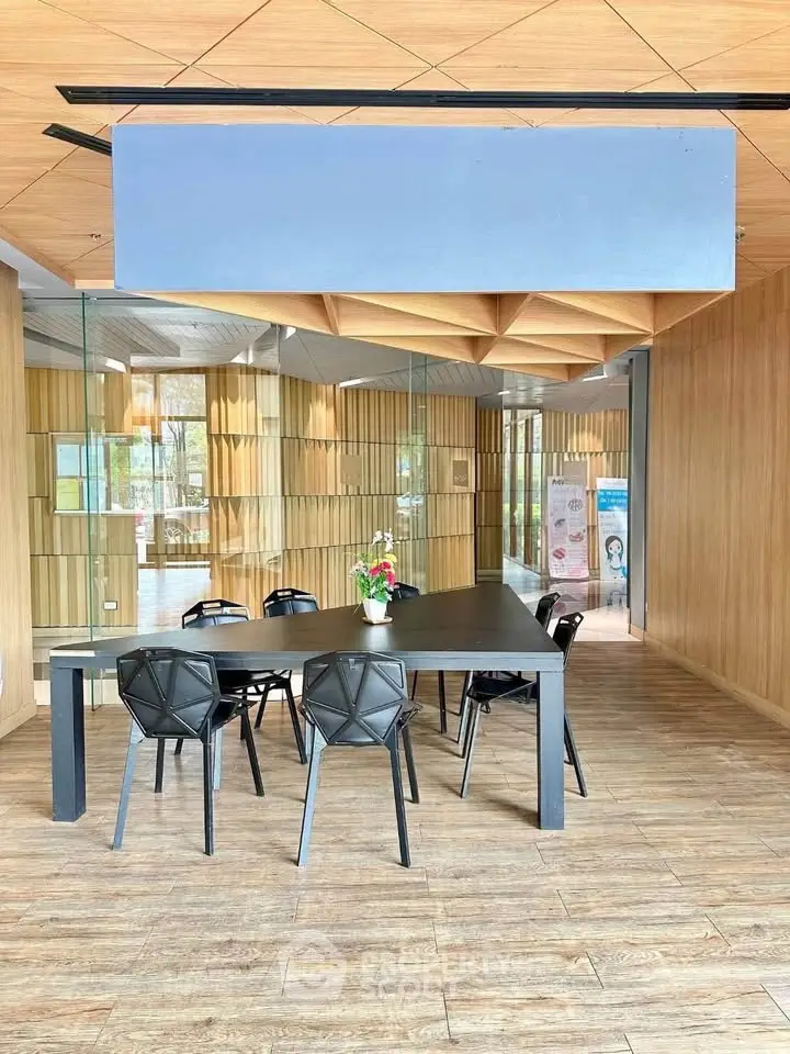 Modern co-working space with stylish furniture and wooden accents in a contemporary building.