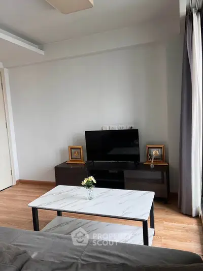 Modern living room with sleek TV stand and marble coffee table, perfect for cozy relaxation.