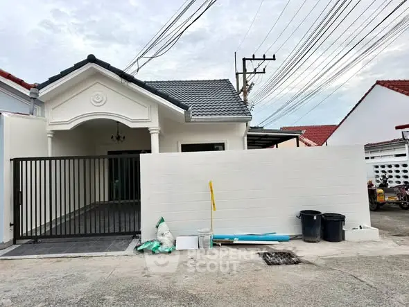 Charming single-story home with gated entrance and modern exterior design.