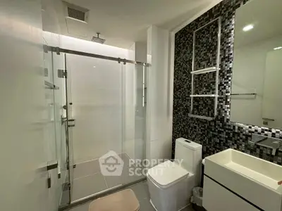 Modern bathroom with sleek shower and stylish black tile accent wall.
