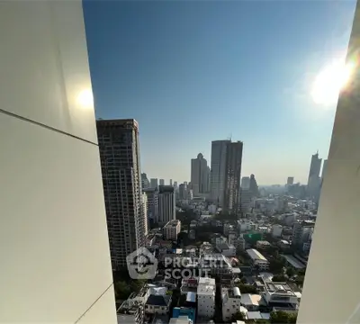 Stunning cityscape view from high-rise building balcony with clear blue sky.