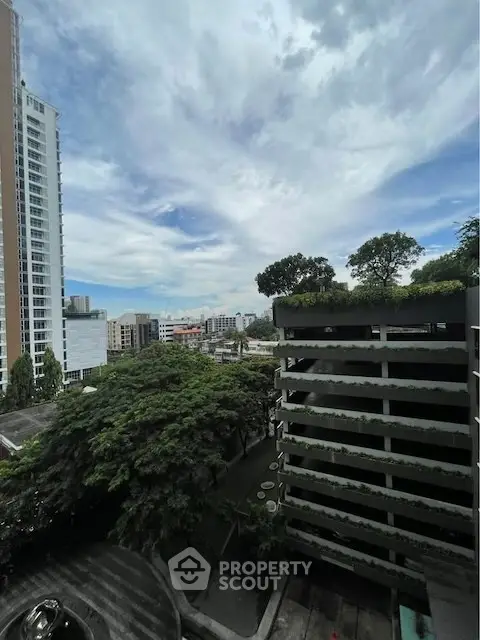 Stunning urban view from high-rise building with lush greenery and cityscape.