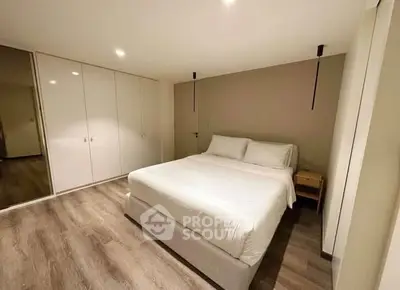 Spacious modern bedroom with elegant design and ample storage space.