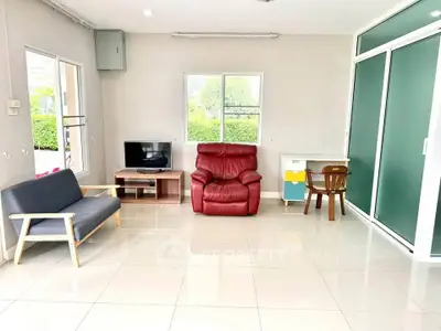Spacious living room with modern furniture and natural light, perfect for relaxation and entertainment.