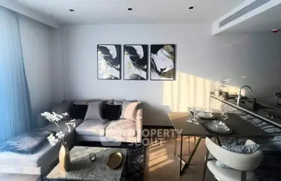 Modern living room with stylish decor and open kitchen layout, featuring elegant furniture and natural light.