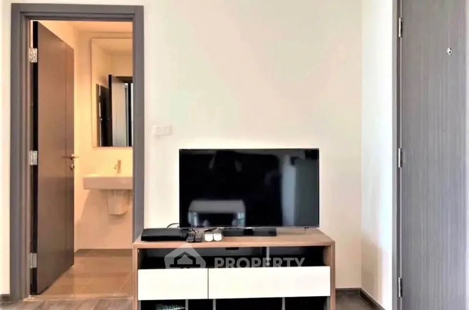 Modern living room with sleek TV stand and open bathroom view