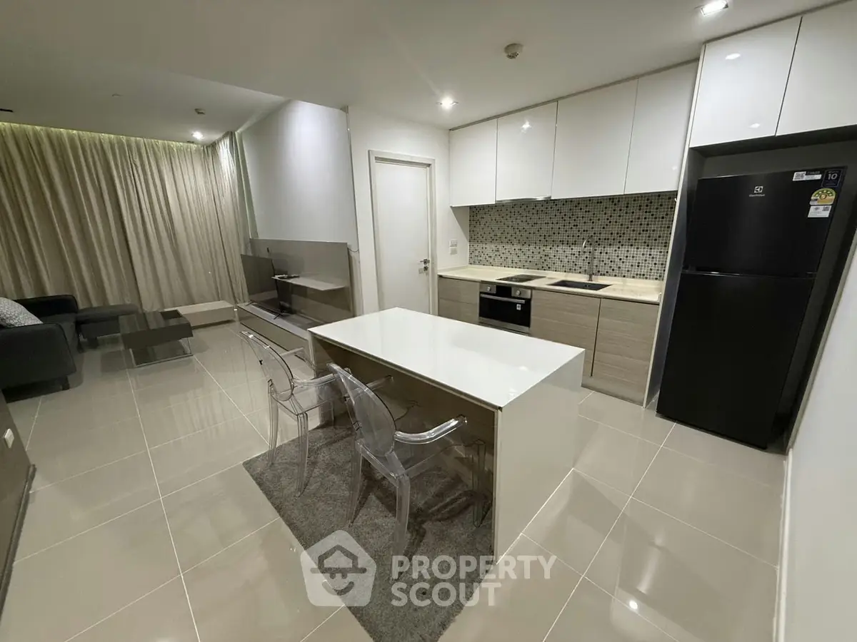 Modern open-layout kitchen and living room with sleek design and contemporary furnishings.