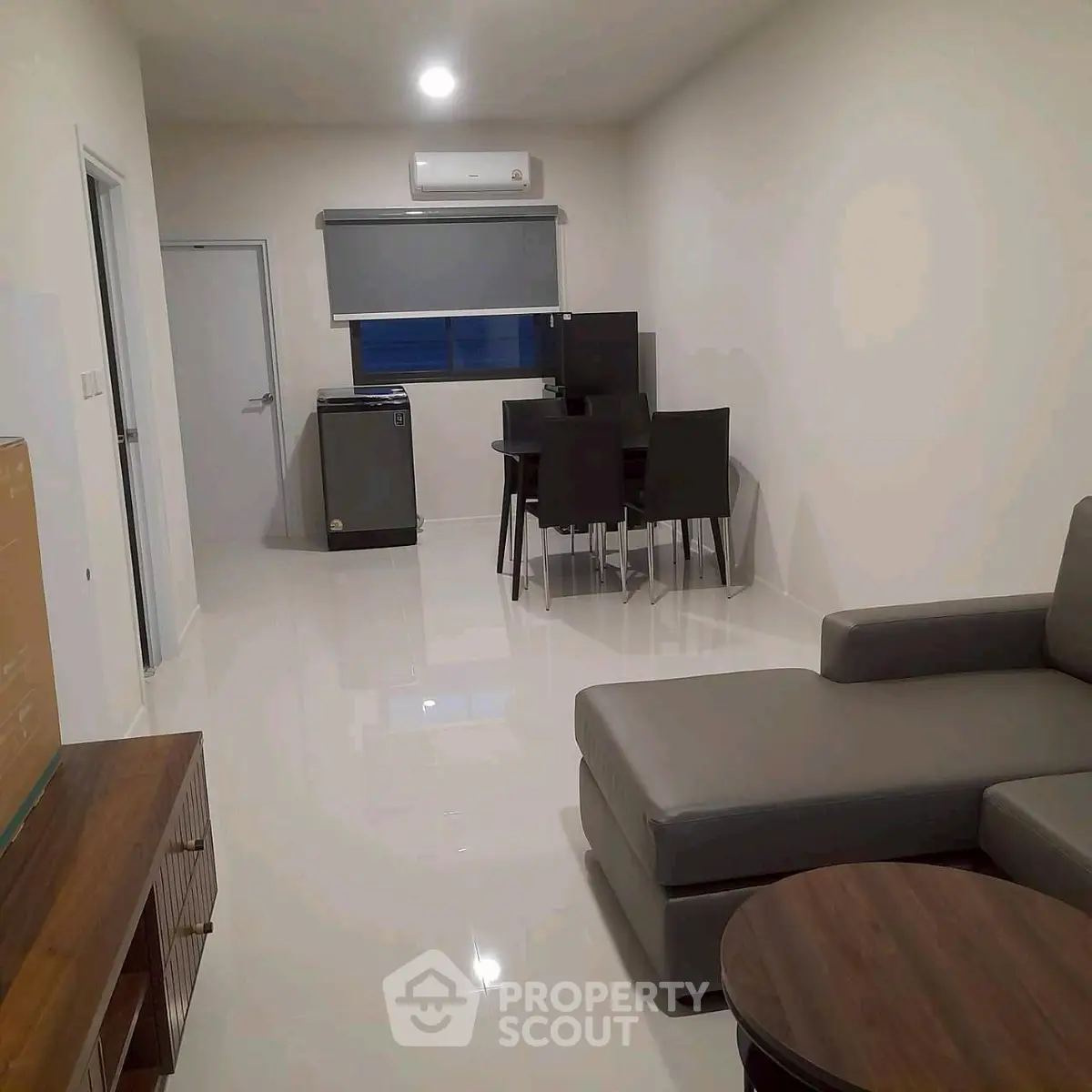 Modern living room with sleek furniture and dining area in a stylish apartment.