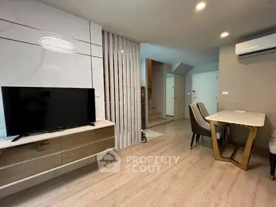 Modern living room with sleek TV setup and stylish dining area