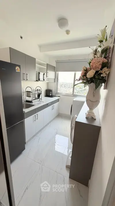 Modern kitchen with sleek cabinets, stainless steel appliances, and elegant floral decor.
